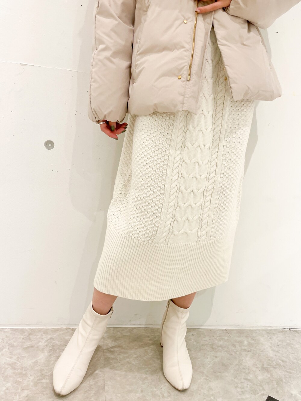 ホワイト系のワンピース、ベージュ系のダウンジャケット/コートを着用したレディースの冬コーディネートの5枚目の写真