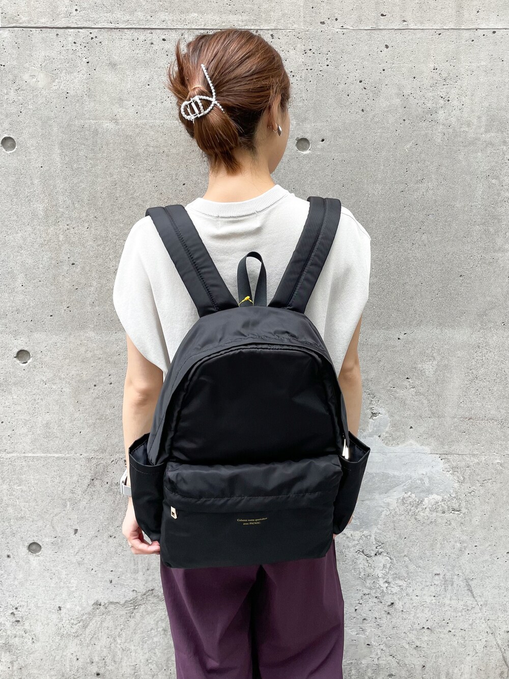 ブラック系のバックパック/リュック、グレー系のニット/セーター、パープル系のその他パンツを着用したレディースの夏コーディネートの5枚目の写真