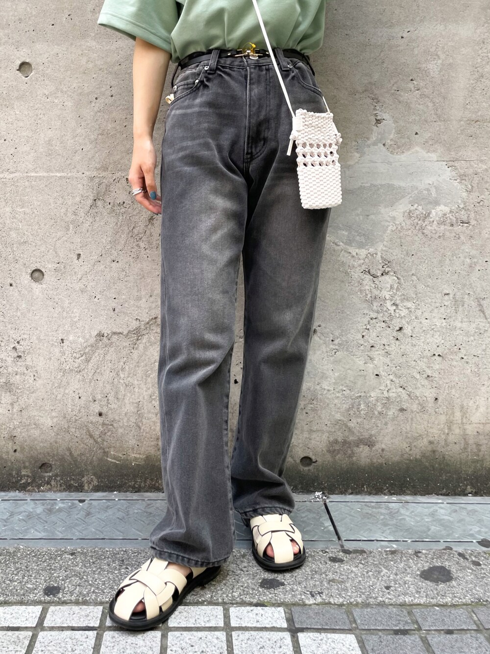 グリーン系のTシャツ/カットソー、ホワイト系のショルダーバッグ、ブラック系のデニムパンツを着用したレディースの夏コーディネートの5枚目の写真