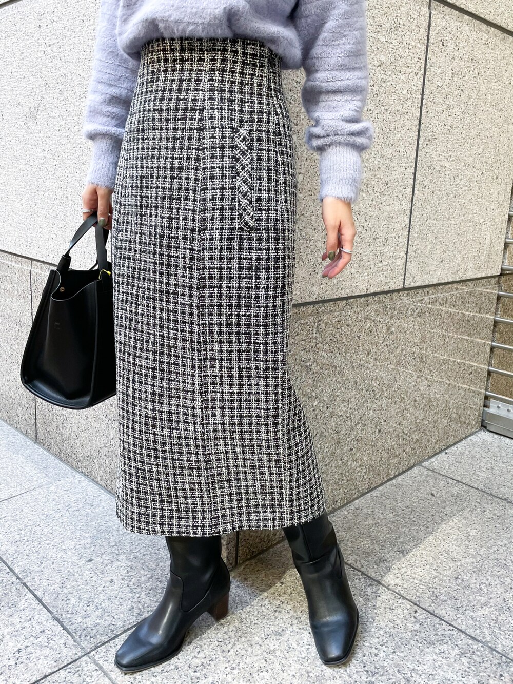 ブルー系のニット/セーター、ブラック系のスカート、ブラック系のトートバッグを着用したレディースの冬コーディネートの5枚目の写真