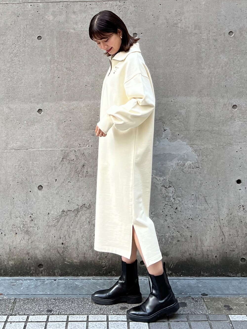 ホワイト系のワンピース、ブルー系のニット/セーター、ブラック系のショルダーバッグを着用したレディースの冬コーディネートの2枚目の写真