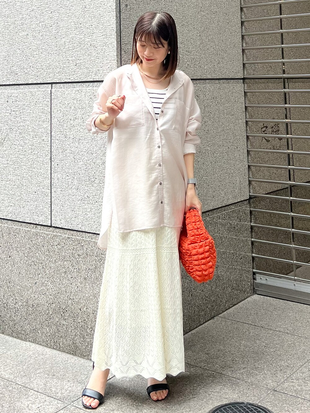 ベージュ系のシャツ/ブラウス、ホワイト系のタンクトップ、オレンジ系のショルダーバッグを着用したレディースの春コーディネートの2枚目の写真