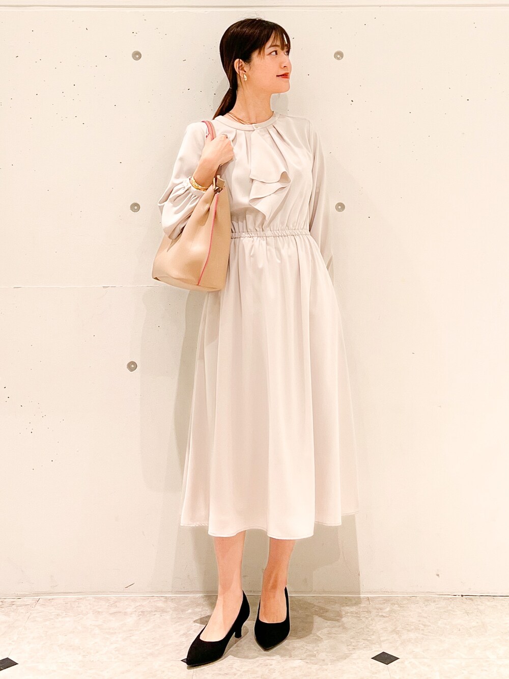 ベージュ系のワンピース、ブラック系のショルダーバッグ、ブルー系のカーディガン/ボレロを着用したレディースの春コーディネートの4枚目の写真