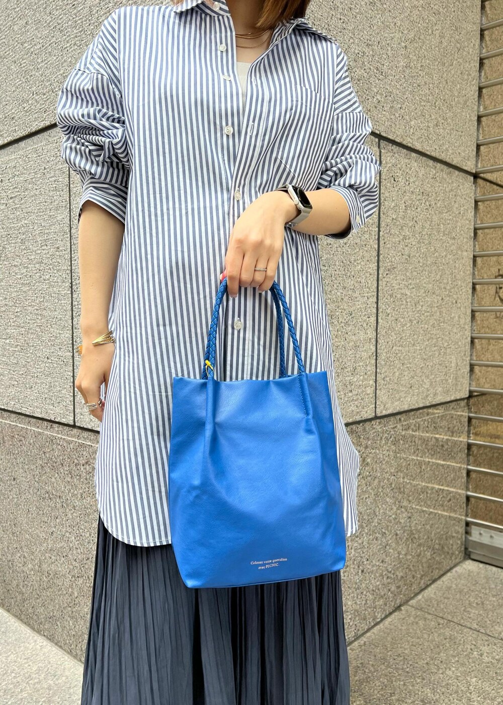ブルー系のトートバッグ、グレー系のタンクトップ、ブルー系のシャツ/ブラウスを着用したレディースの春コーディネートの3枚目の写真
