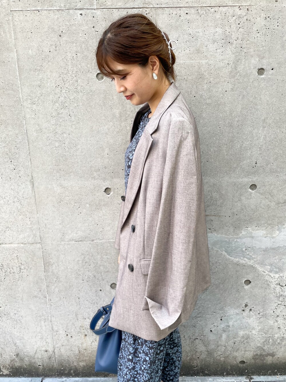 ベージュ系のテーラードジャケット、ブルー系のワンピース、ブルー系のトートバッグを着用したレディースの秋コーディネートの4枚目の写真