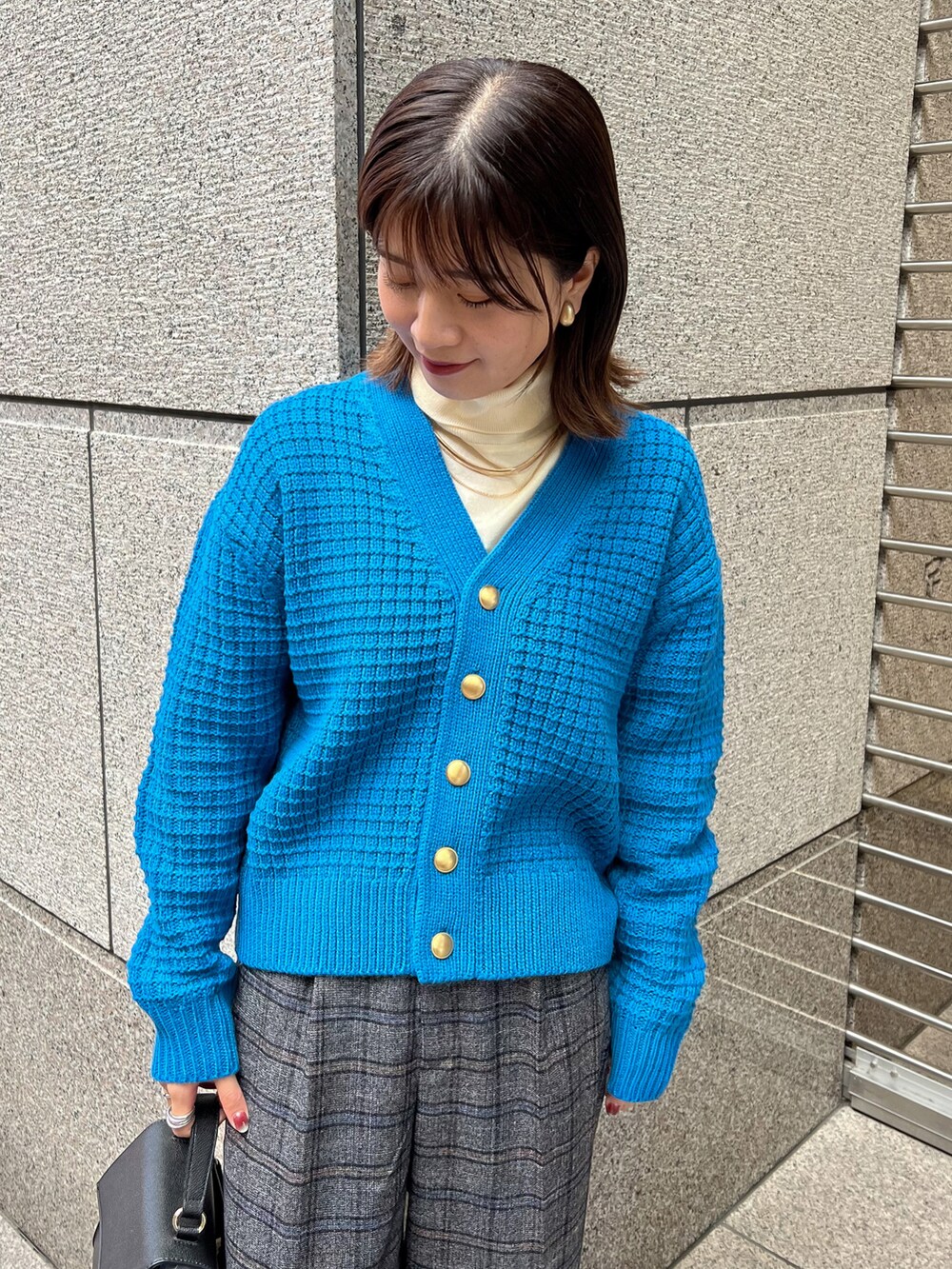 ブルー系のカーディガン/ボレロ、ホワイト系のニット/セーター、ブラック系のショルダーバッグを着用したレディースの冬コーディネートの3枚目の写真