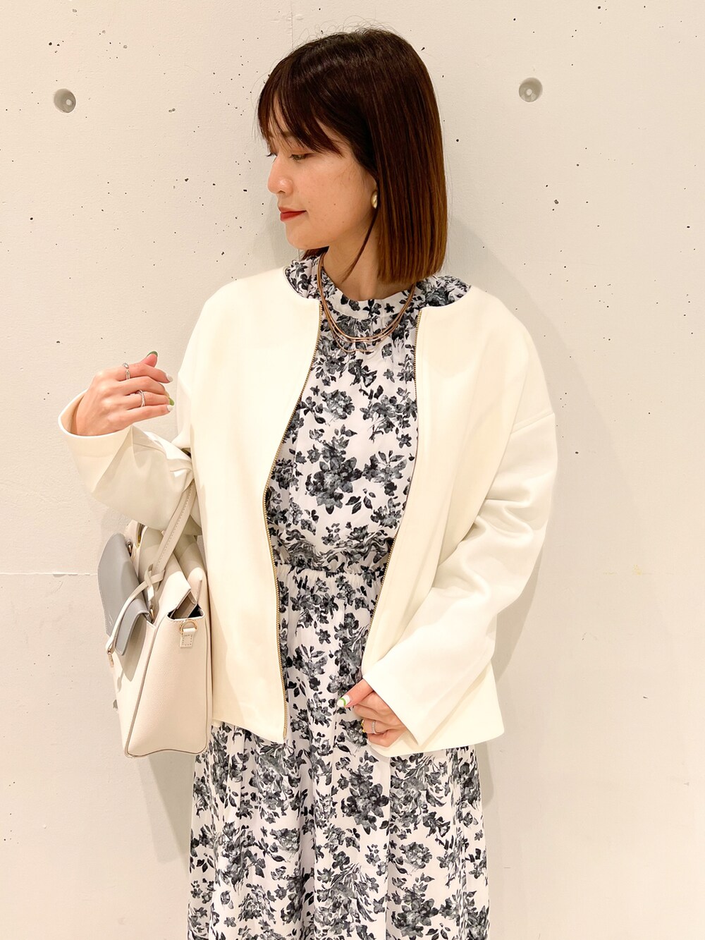 ホワイト系のブルゾン、ホワイト系のワンピース、ホワイト系のショルダーバッグを着用したレディースの春コーディネートの3枚目の写真