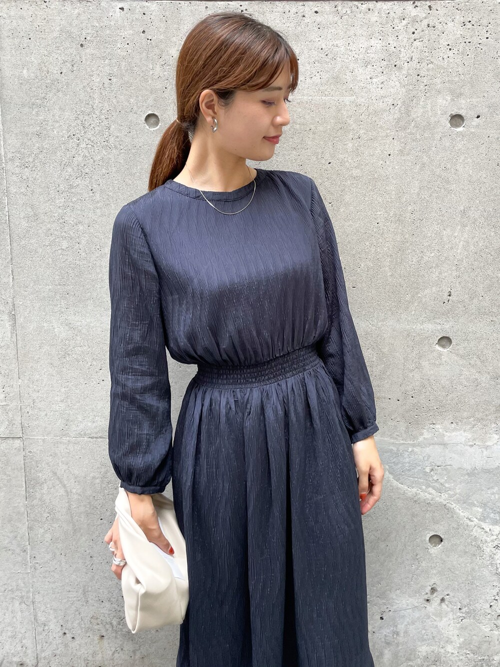 ブルー系のワンピース、ホワイト系のショルダーバッグ、ホワイト系のブーツを着用したレディースの秋コーディネートの3枚目の写真