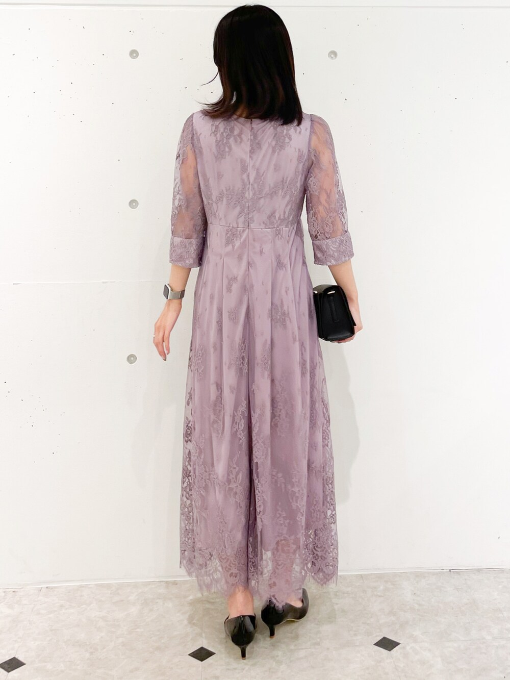 ピンク系のドレス、ブラック系のショルダーバッグ、ブラック系のパンプスを着用したレディースの冬コーディネートの3枚目の写真