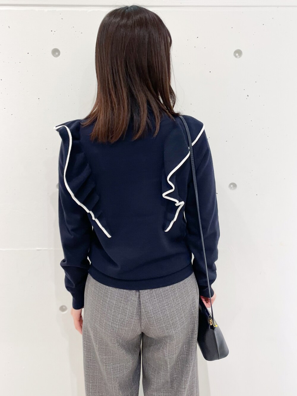ブルー系のニット/セーター、ブルー系のショルダーバッグ、グレー系のその他パンツを着用したレディースの冬コーディネートの5枚目の写真