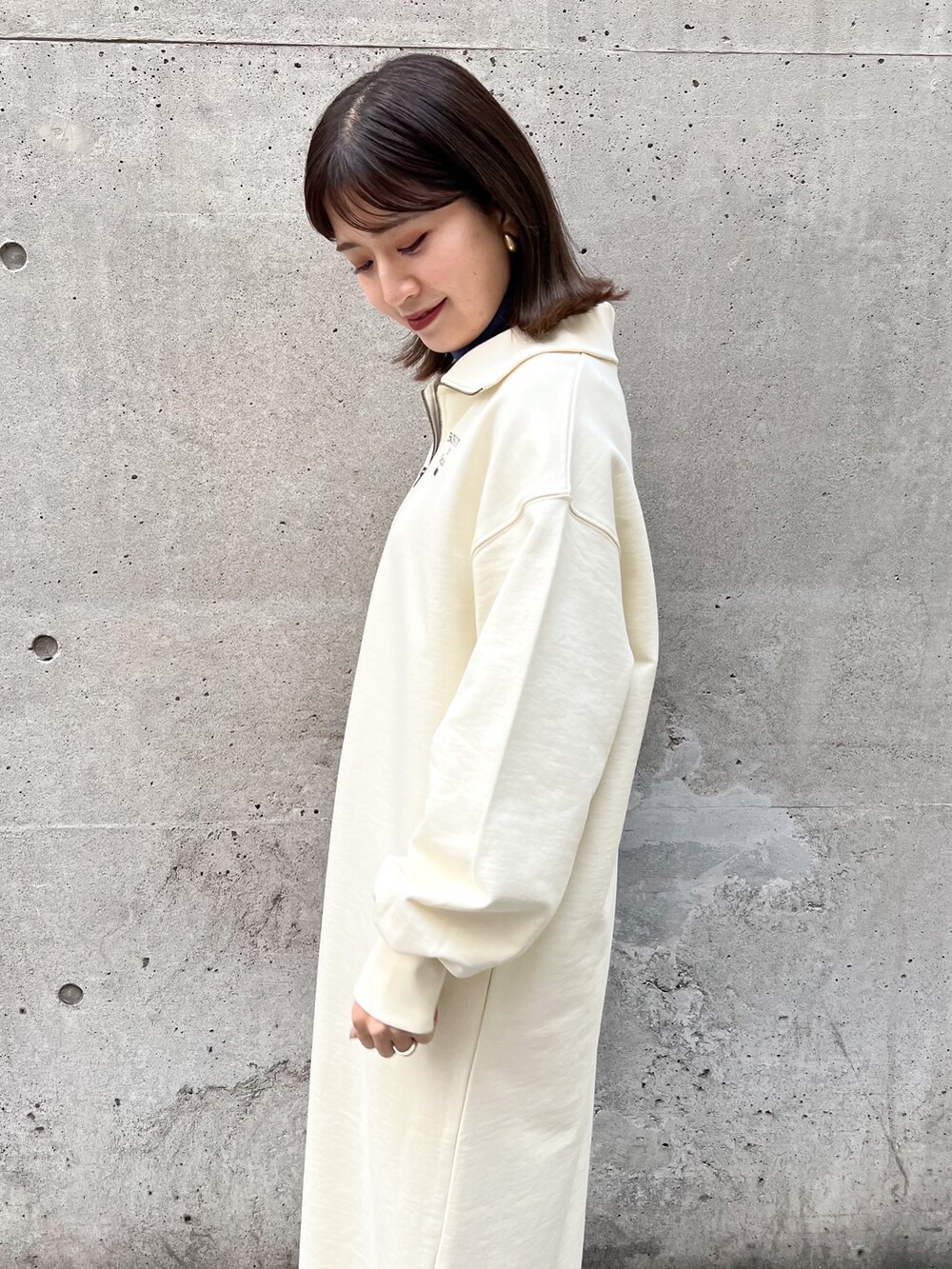 ホワイト系のワンピース、ブルー系のニット/セーター、ブラック系のショルダーバッグを着用したレディースの冬コーディネートの5枚目の写真