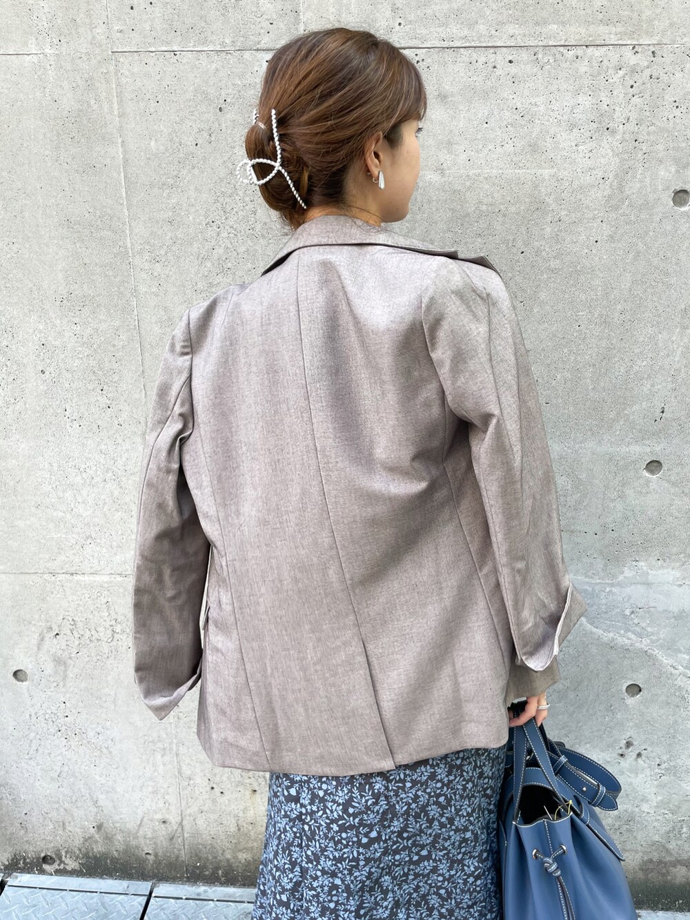 ベージュ系のテーラードジャケット、ブルー系のワンピース、ブルー系のトートバッグを着用したレディースの秋コーディネートの5枚目の写真