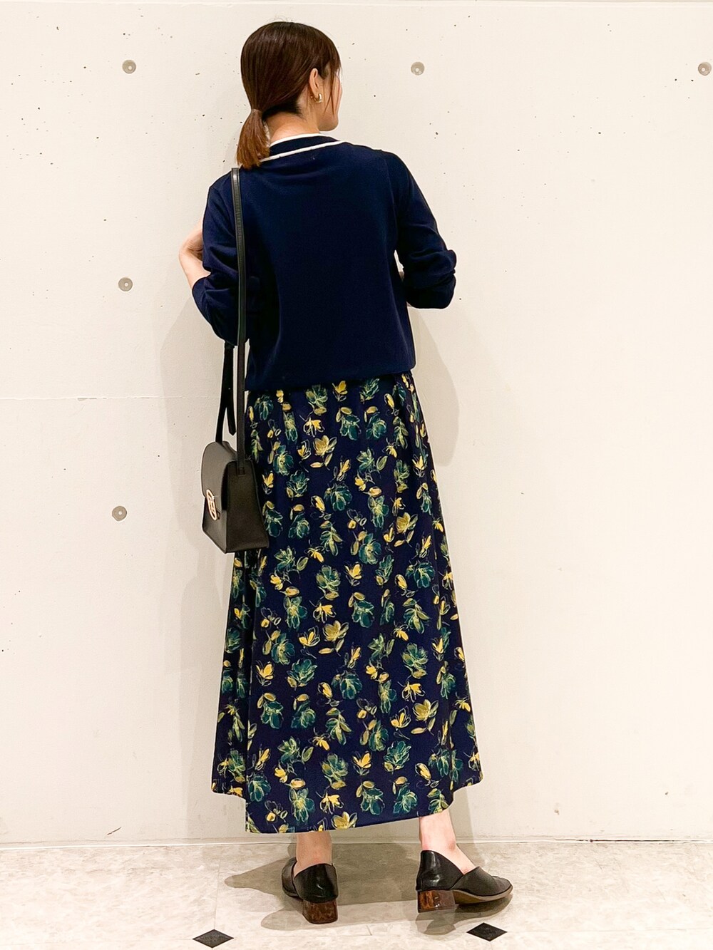 ブルー系のカーディガン/ボレロ、ブルー系のスカート、ブラック系のショルダーバッグを着用したレディースの春コーディネートの3枚目の写真