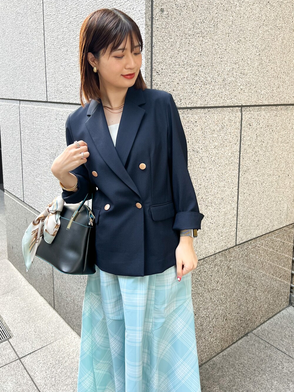 ブルー系のテーラードジャケット、ブラック系のショルダーバッグ、ブルー系のスカートを着用したレディースの春コーディネートの4枚目の写真