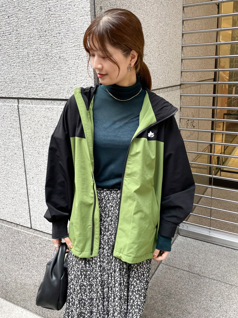 グリーン系のTシャツ/カットソー、グリーン系のマウンテンパーカー、ブラック系のショルダーバッグを着用したレディースの秋コーディネートの3枚目の写真