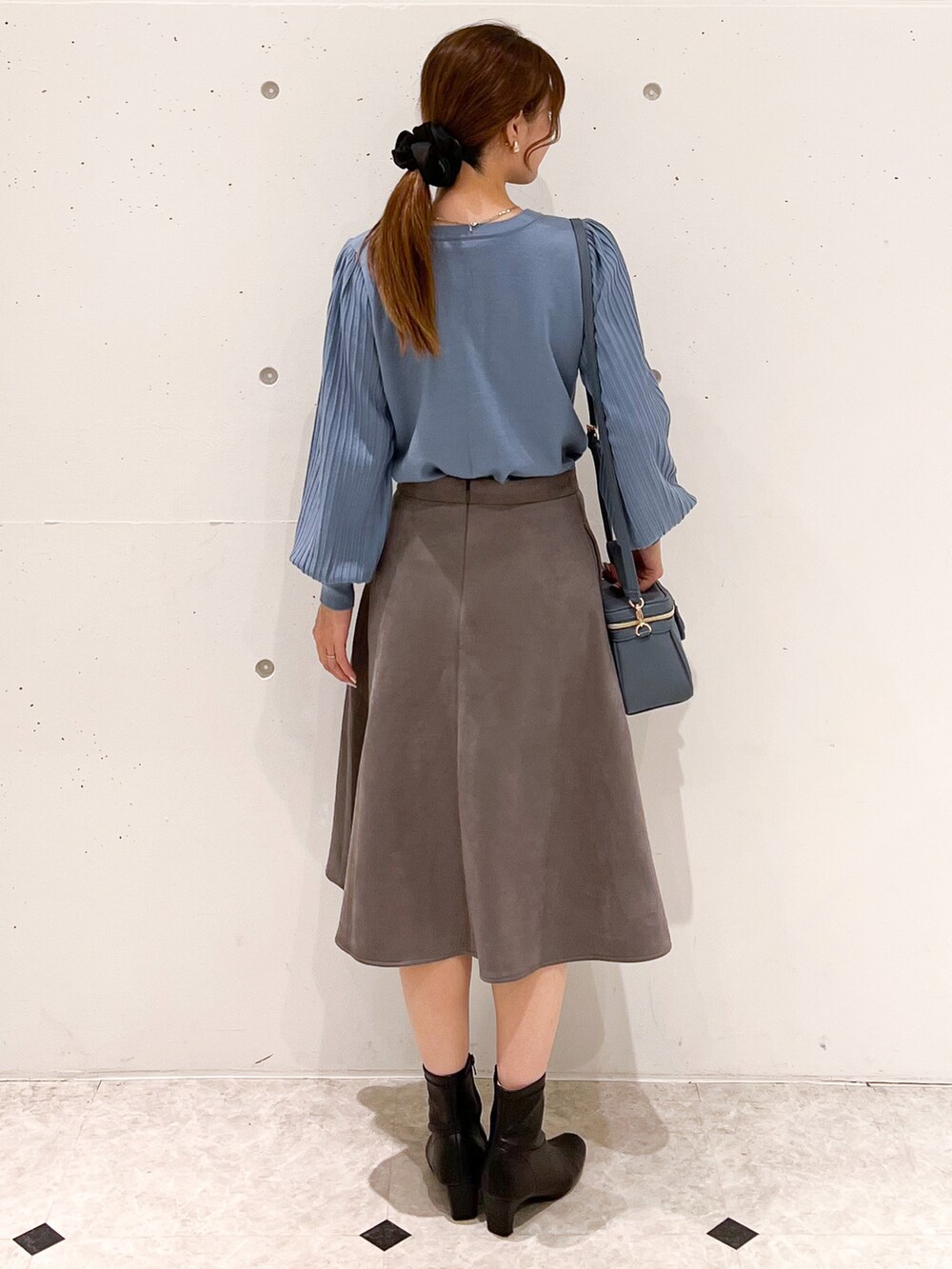 ブルー系のカーディガン/ボレロ、ブルー系のショルダーバッグ、グレー系のスカートを着用したレディースの秋コーディネートの2枚目の写真