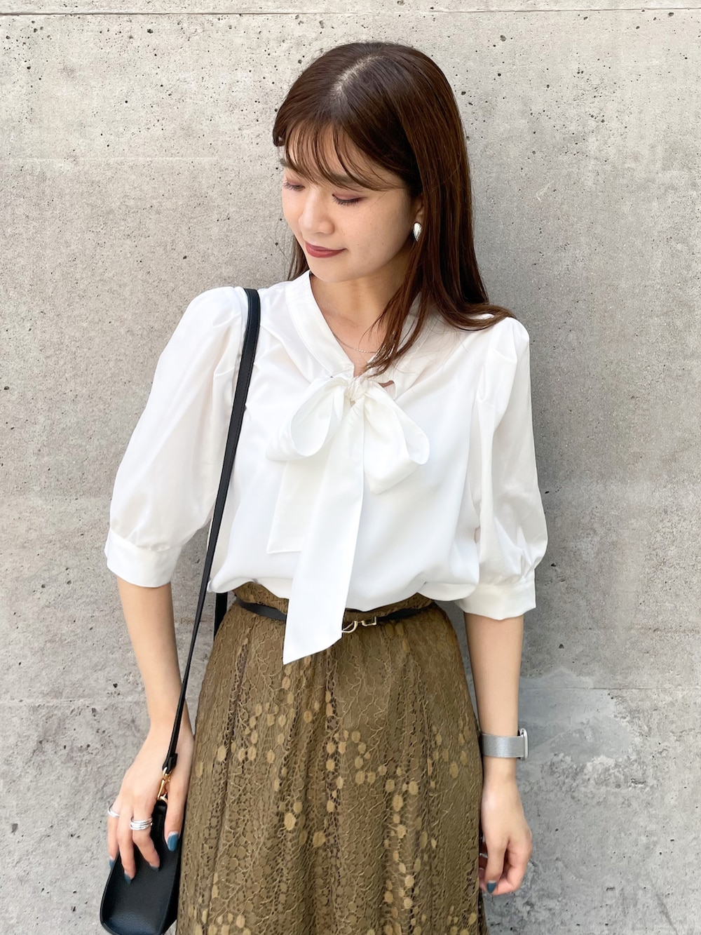 ブラック系のショルダーバッグ、グリーン系のスカート、ブラック系のサンダルを着用したレディースの夏コーディネートの3枚目の写真