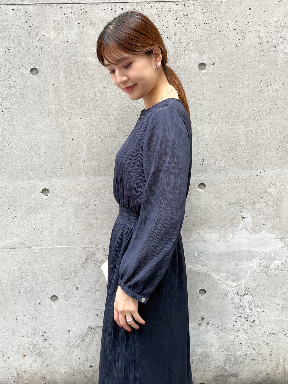 ブルー系のワンピース、ホワイト系のショルダーバッグ、ホワイト系のブーツを着用したレディースの秋コーディネートの4枚目の写真