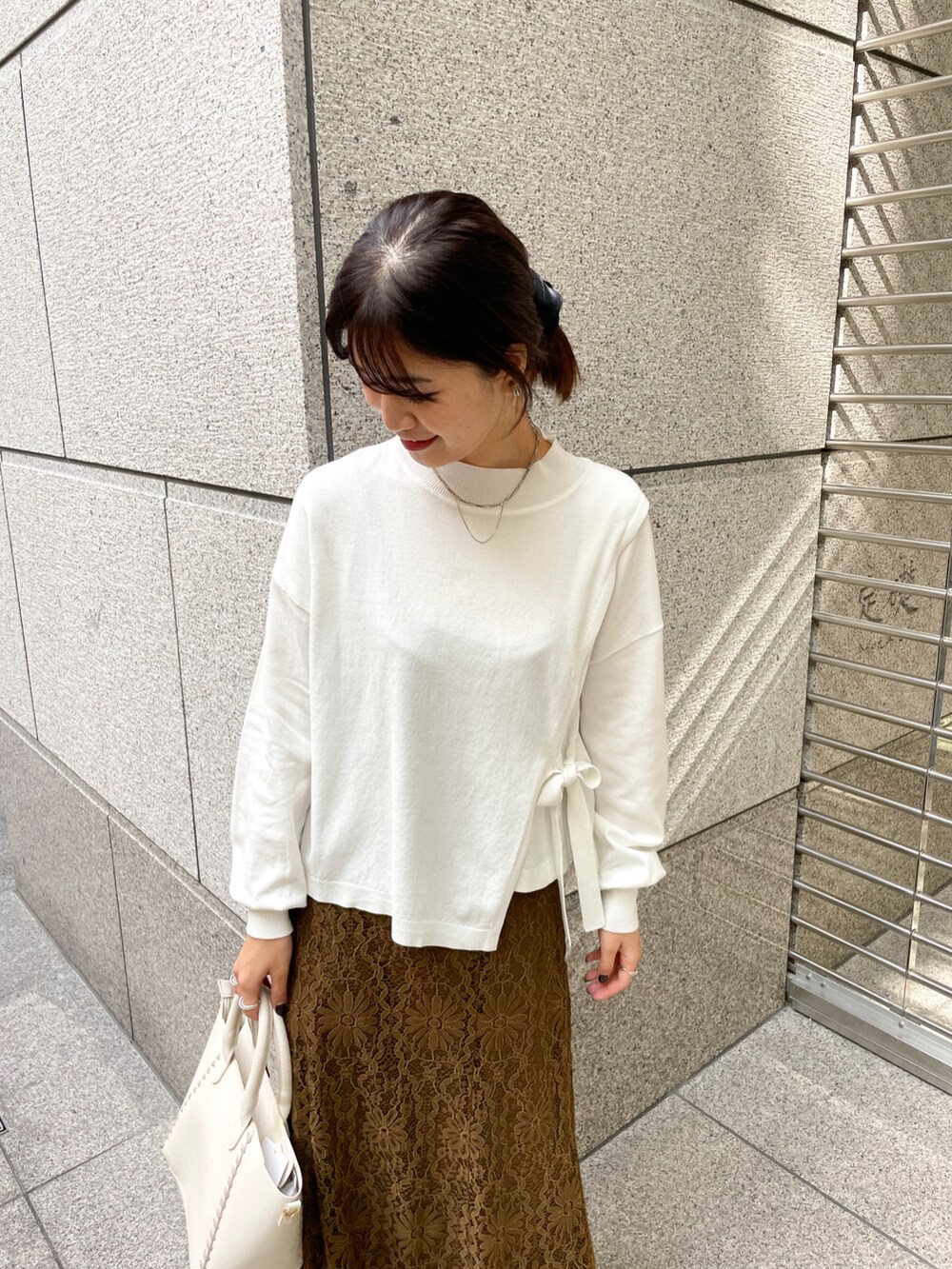 ホワイト系のニット/セーター、グリーン系のスカート、ホワイト系のショルダーバッグを着用したレディースの冬コーディネートの3枚目の写真