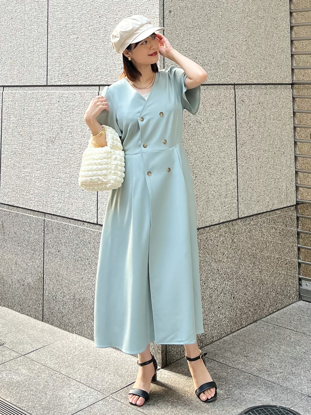 ベージュ系のブルゾン、グリーン系のワンピース、ホワイト系のショルダーバッグを着用したレディースの春コーディネートの3枚目の写真