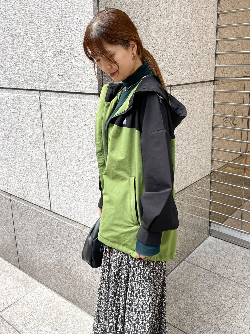 グリーン系のTシャツ/カットソー、グリーン系のマウンテンパーカー、ブラック系のショルダーバッグを着用したレディースの秋コーディネートの4枚目の写真