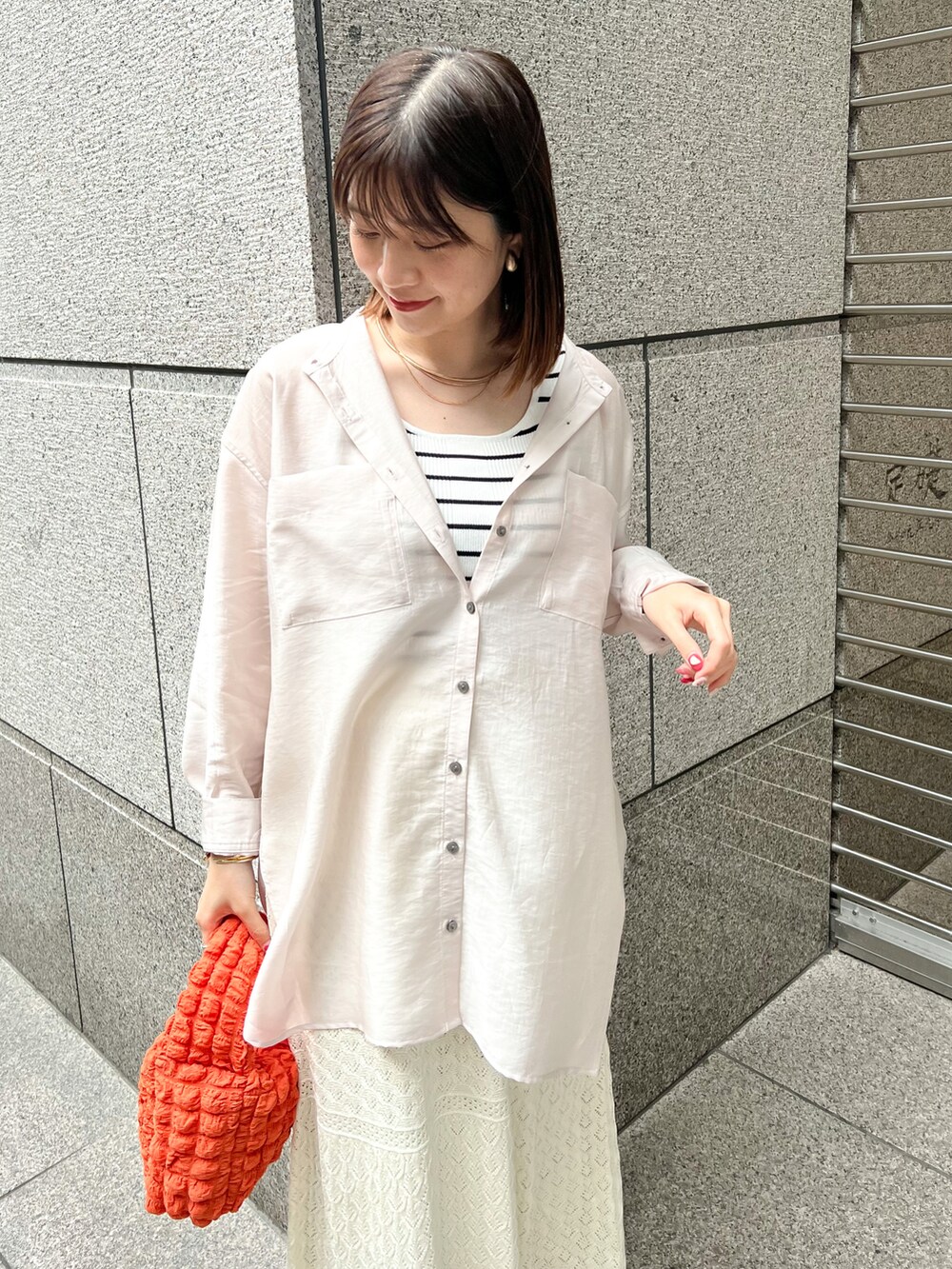 ベージュ系のシャツ/ブラウス、ホワイト系のタンクトップ、オレンジ系のショルダーバッグを着用したレディースの春コーディネートの4枚目の写真