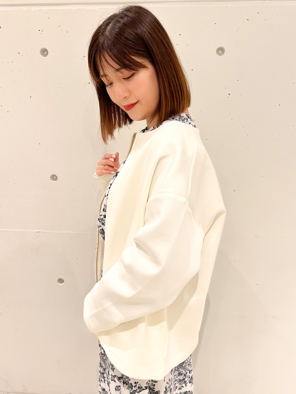 ホワイト系のブルゾン、ホワイト系のワンピース、ホワイト系のショルダーバッグを着用したレディースの春コーディネートの4枚目の写真