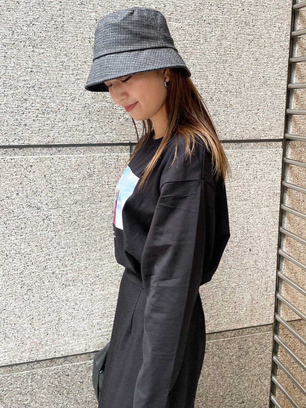 ブラック系のスカート、ブラック系のTシャツ/カットソー、ブラック系のショルダーバッグを着用したレディースの秋コーディネートの3枚目の写真