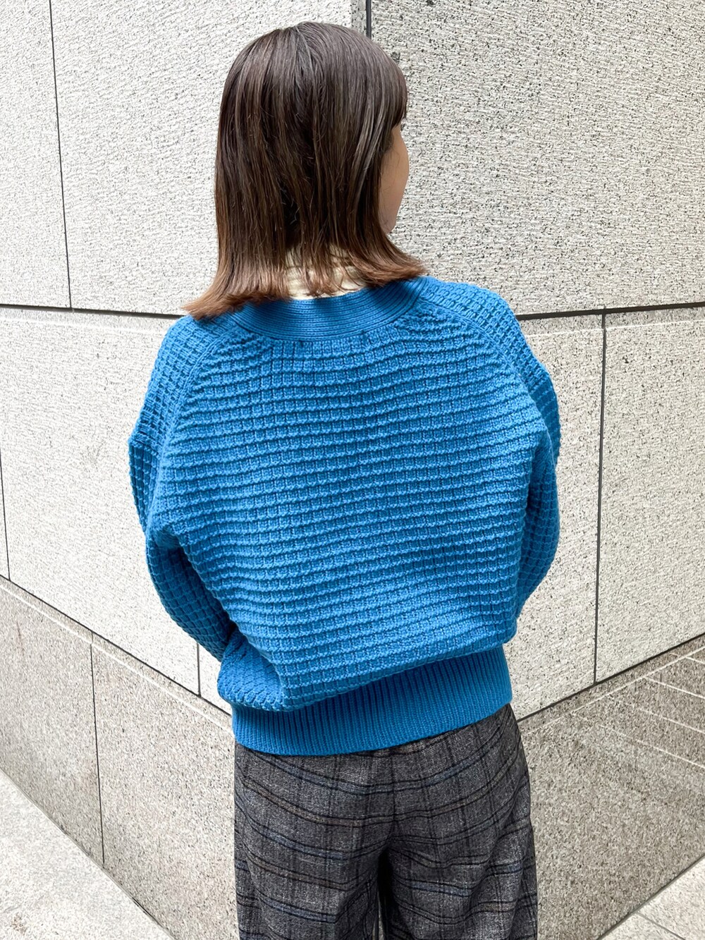 ブルー系のカーディガン/ボレロ、ホワイト系のニット/セーター、ブラック系のショルダーバッグを着用したレディースの冬コーディネートの5枚目の写真