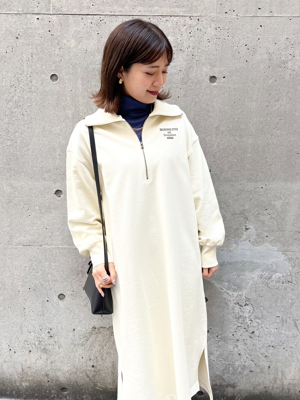 ホワイト系のワンピース、ブルー系のニット/セーター、ブラック系のショルダーバッグを着用したレディースの冬コーディネートの4枚目の写真