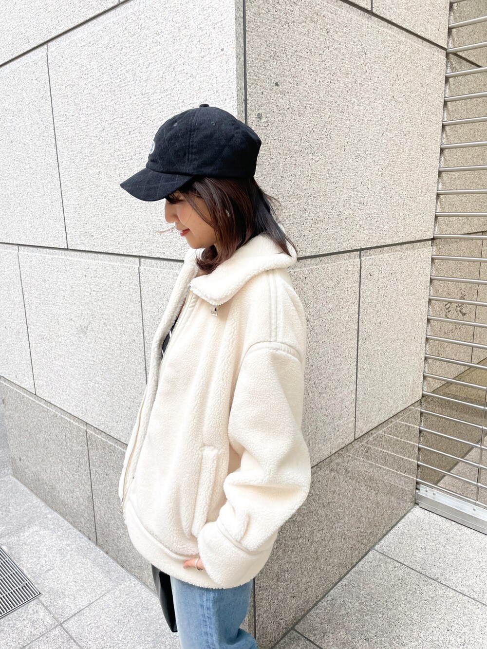 ブラック系のニット/セーター、ブラック系のブーツ、ブルー系のデニムパンツを着用したレディースの冬コーディネートの4枚目の写真