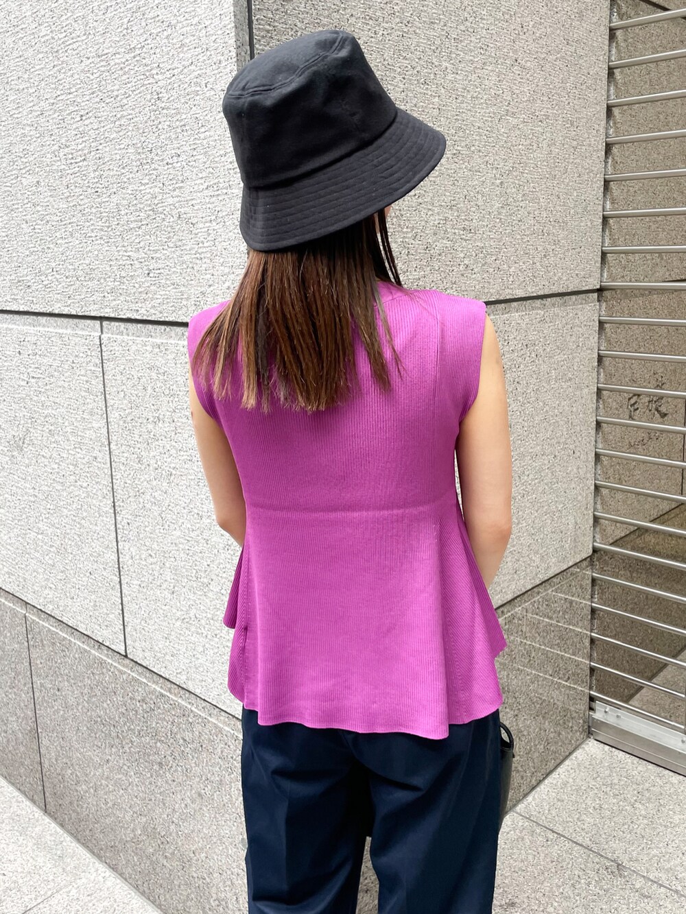レッド系のニット/セーター、ブラック系のショルダーバッグ、ブルー系のチノパンツを着用したレディースの春コーディネートの5枚目の写真