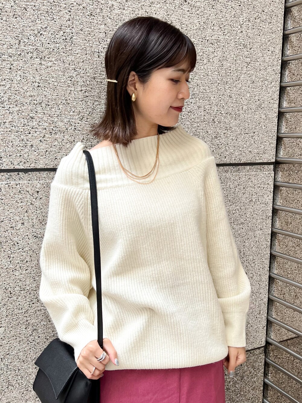 ホワイト系のニット/セーター、ブラック系のショルダーバッグ、ピンク系のスカートを着用したレディースの冬コーディネートの3枚目の写真