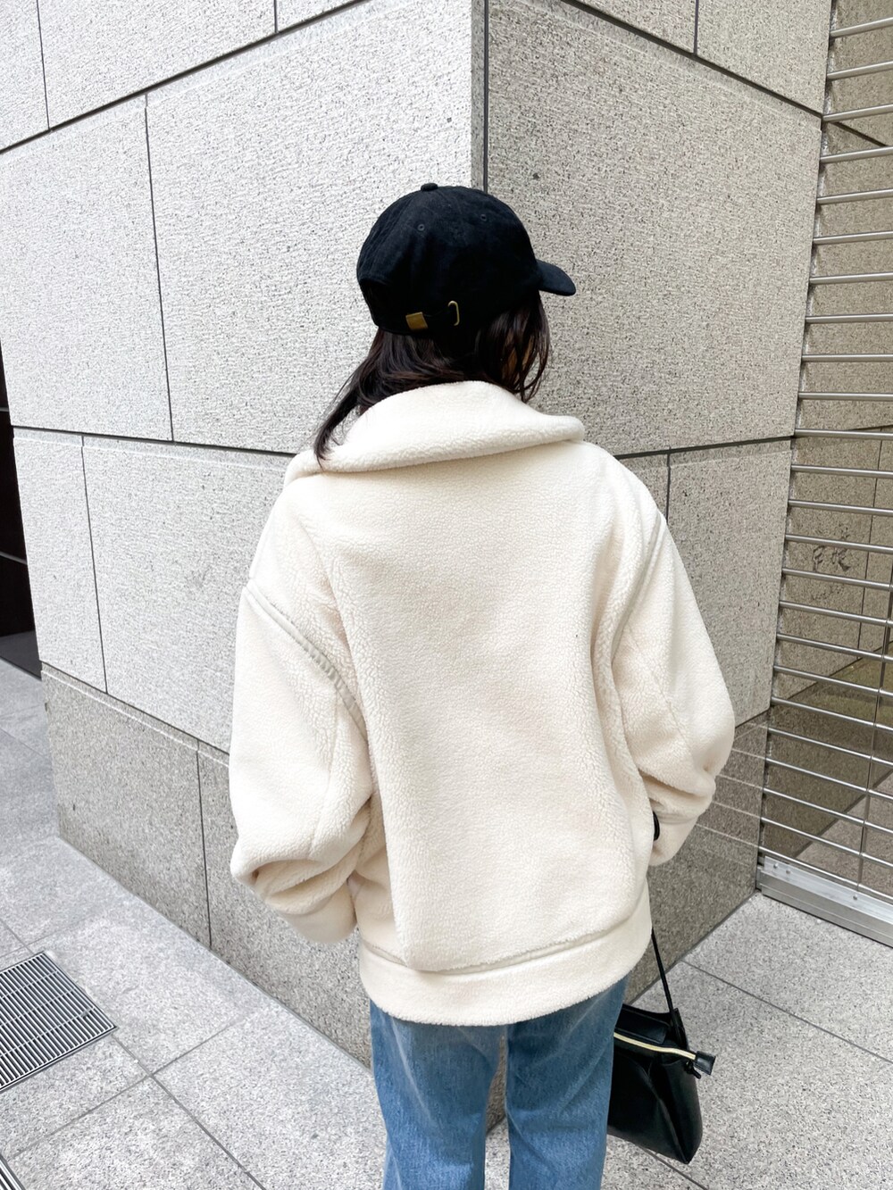 ブラック系のニット/セーター、ブラック系のブーツ、ブルー系のデニムパンツを着用したレディースの冬コーディネートの5枚目の写真