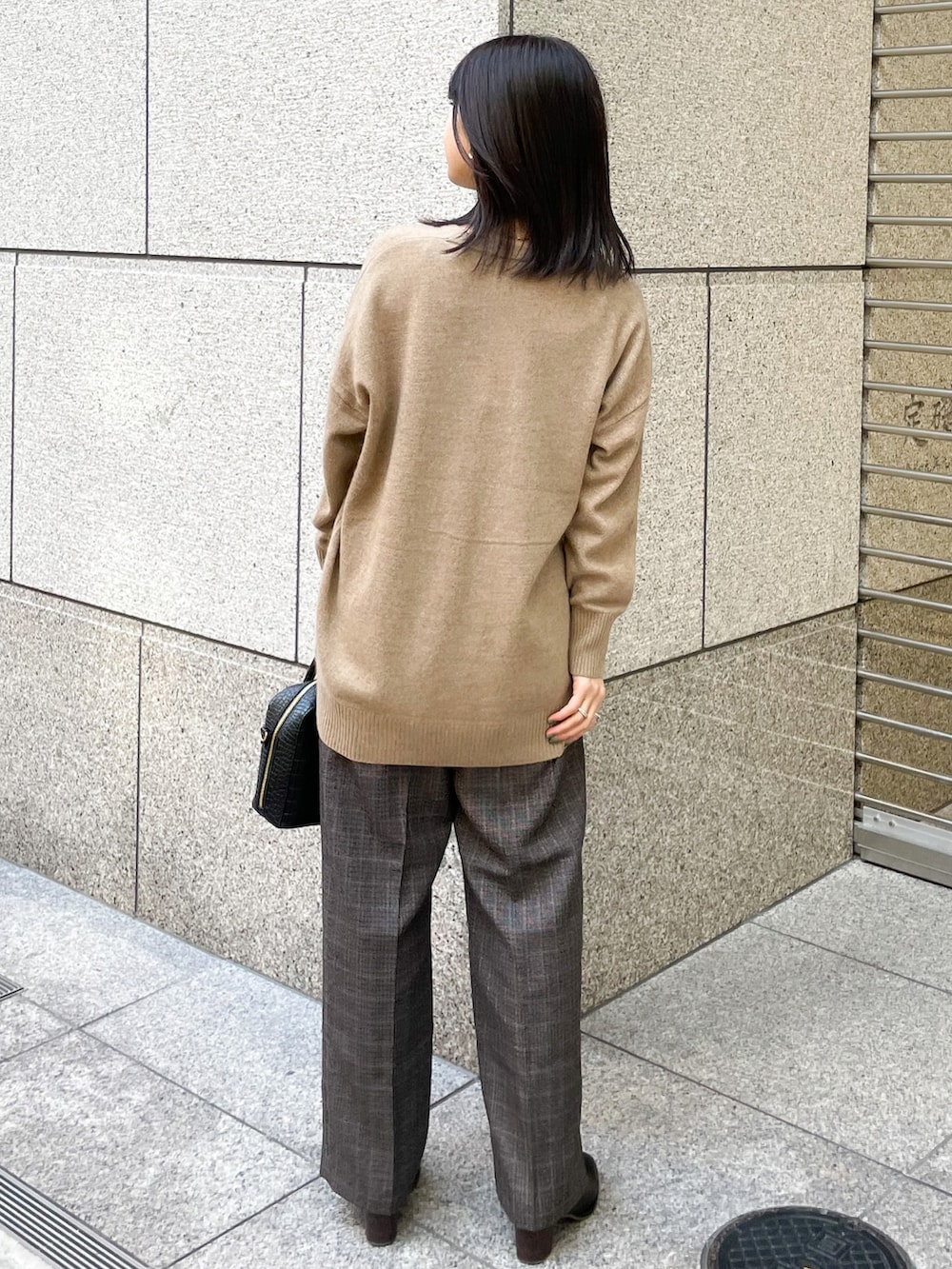 ブラウン系のニット/セーター、ブラック系のその他パンツ、ブラック系のショルダーバッグを着用したレディースの冬コーディネートの2枚目の写真