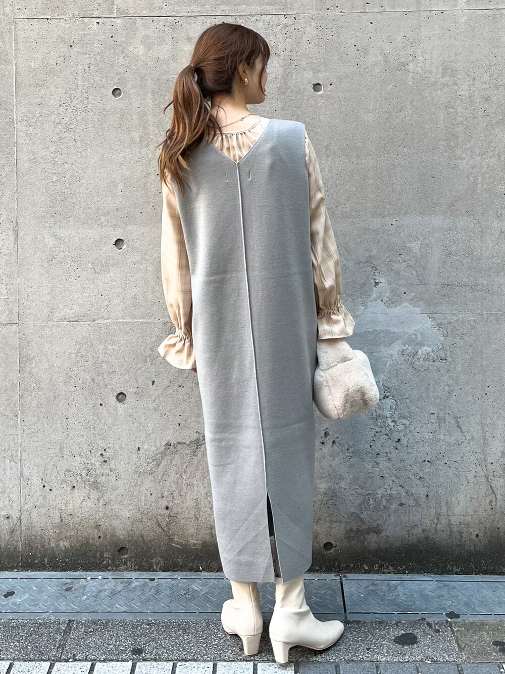 グレー系のジャンパースカート、ベージュ系のショルダーバッグ、ベージュ系のシャツ/ブラウスを着用したレディースの秋コーディネートの2枚目の写真