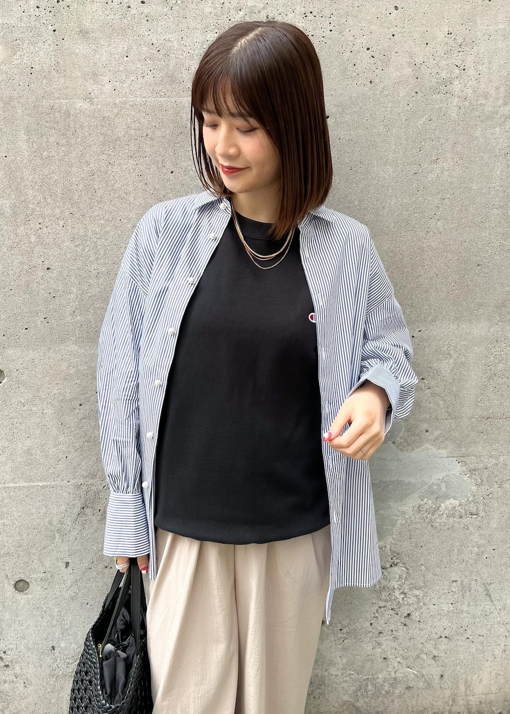 ベージュ系のその他パンツ、ブラック系のトートバッグ、ブルー系のシャツ/ブラウスを着用したレディースの春コーディネートの3枚目の写真