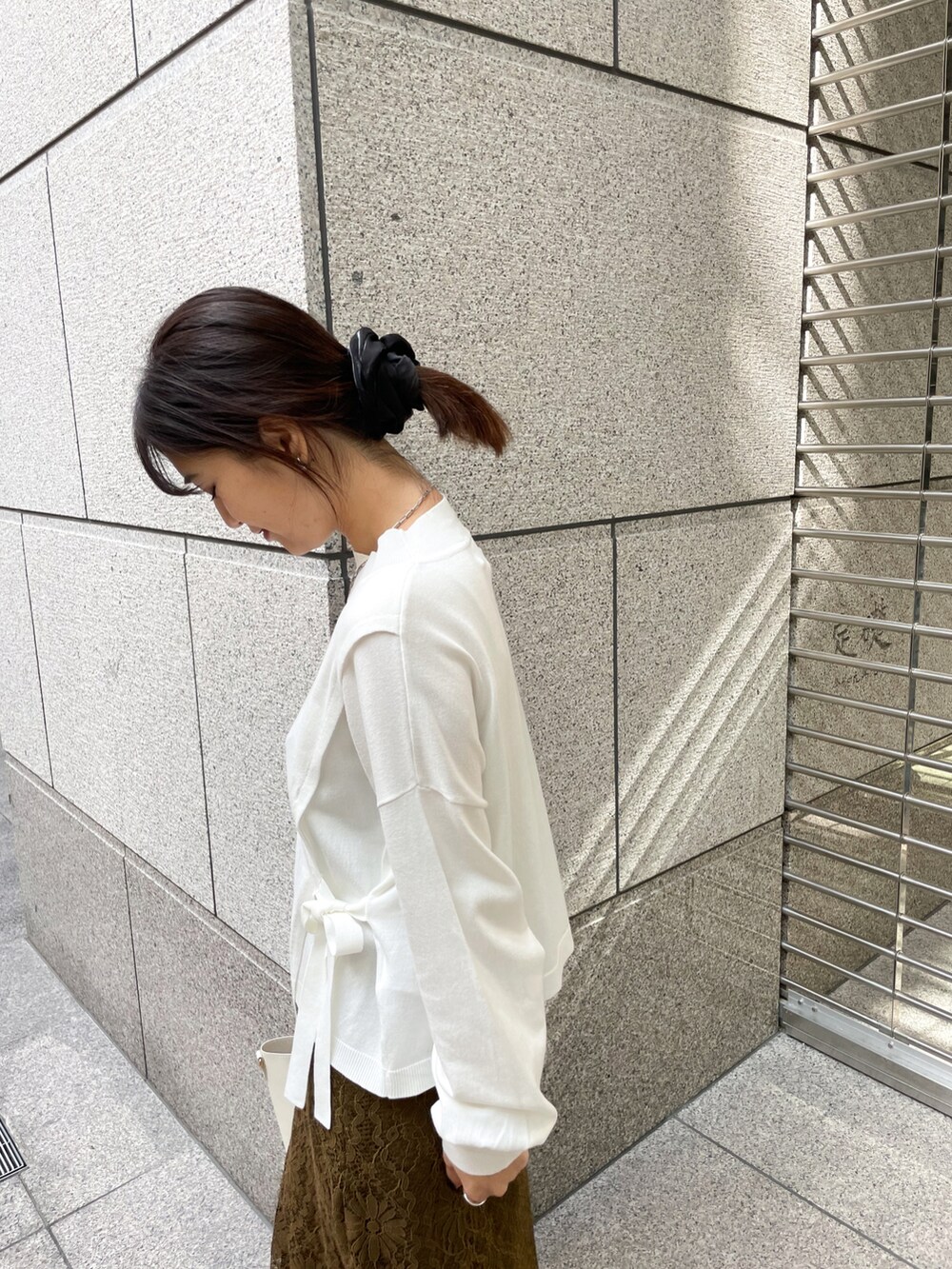 ホワイト系のニット/セーター、グリーン系のスカート、ホワイト系のショルダーバッグを着用したレディースの冬コーディネートの4枚目の写真