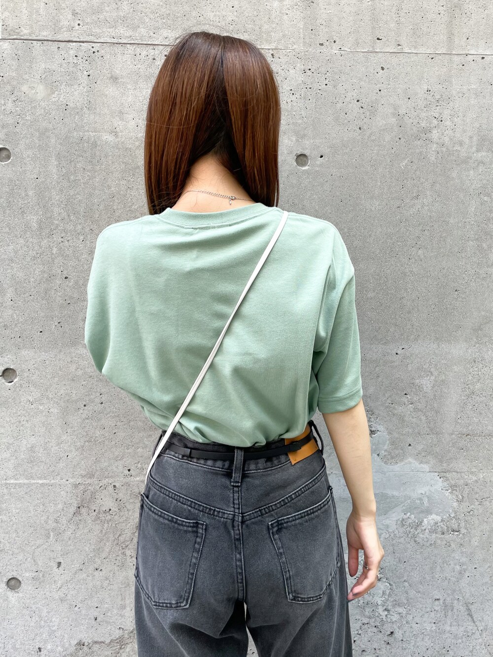 グリーン系のTシャツ/カットソー、ホワイト系のショルダーバッグ、ブラック系のデニムパンツを着用したレディースの夏コーディネートの4枚目の写真