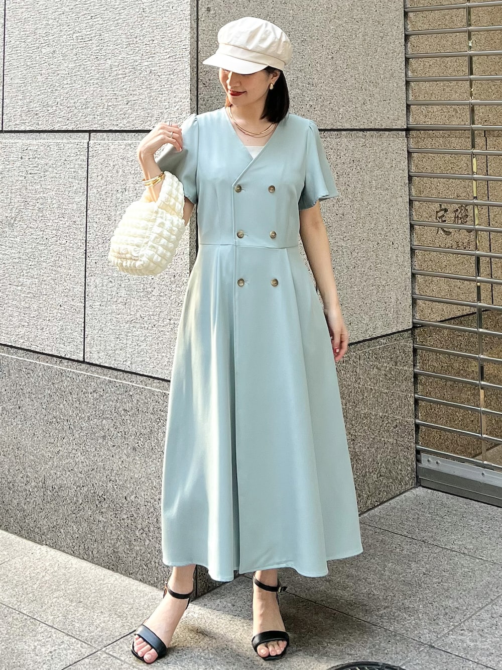 ベージュ系のブルゾン、グリーン系のワンピース、ホワイト系のショルダーバッグを着用したレディースの春コーディネートの4枚目の写真