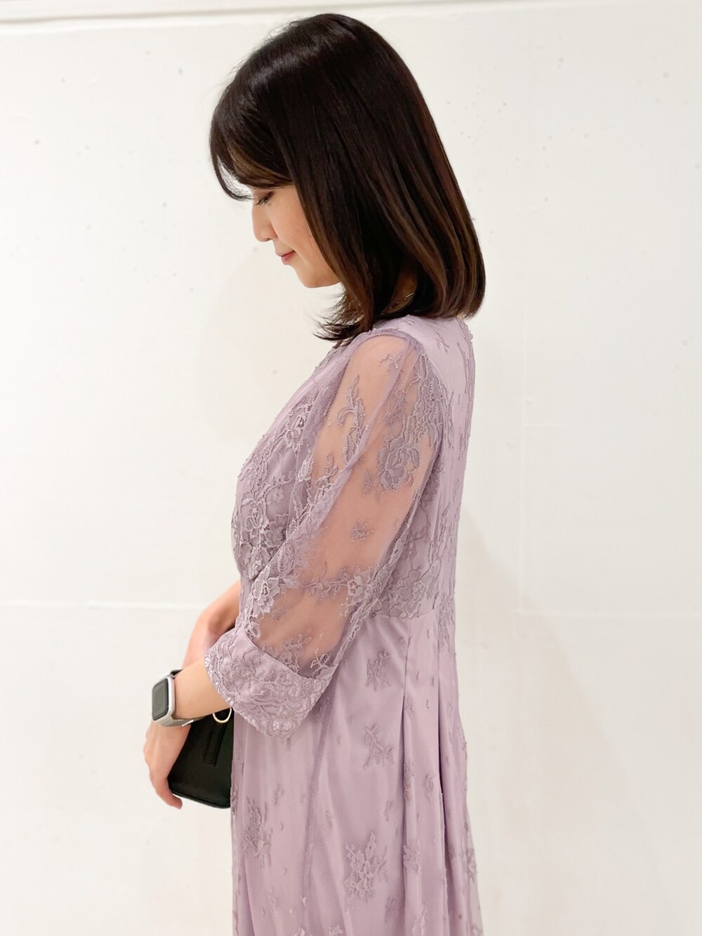 ピンク系のドレス、ブラック系のショルダーバッグ、ブラック系のパンプスを着用したレディースの冬コーディネートの5枚目の写真