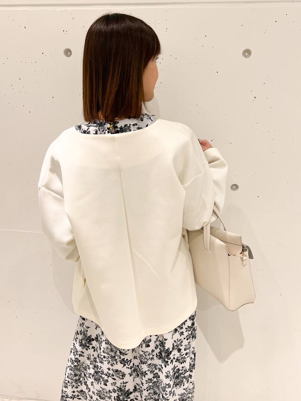 ホワイト系のブルゾン、ホワイト系のワンピース、ホワイト系のショルダーバッグを着用したレディースの春コーディネートの5枚目の写真