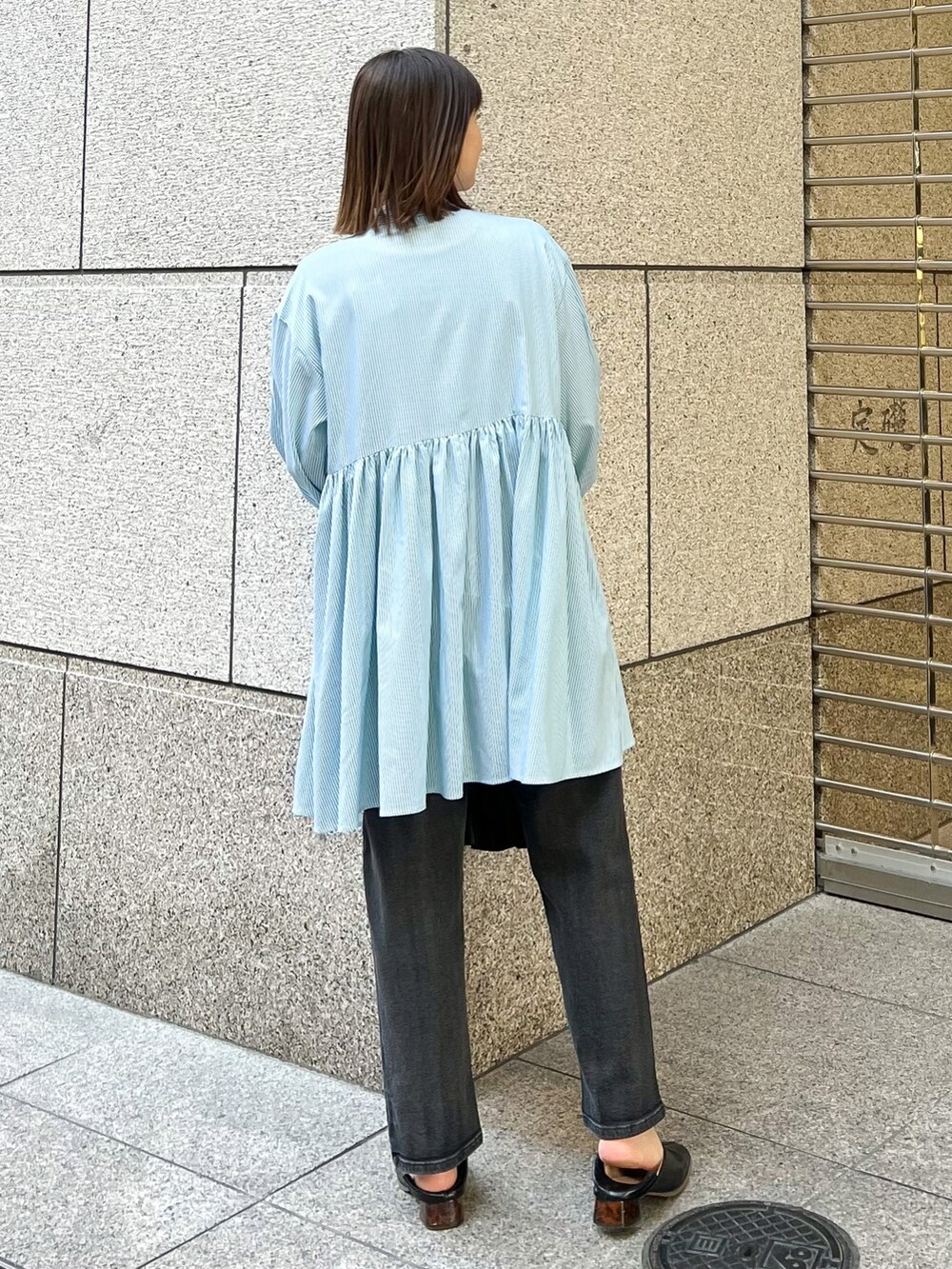 ブルー系のシャツ/ブラウス、ホワイト系のTシャツ/カットソー、ブラック系のトートバッグを着用したレディースの春コーディネートの2枚目の写真