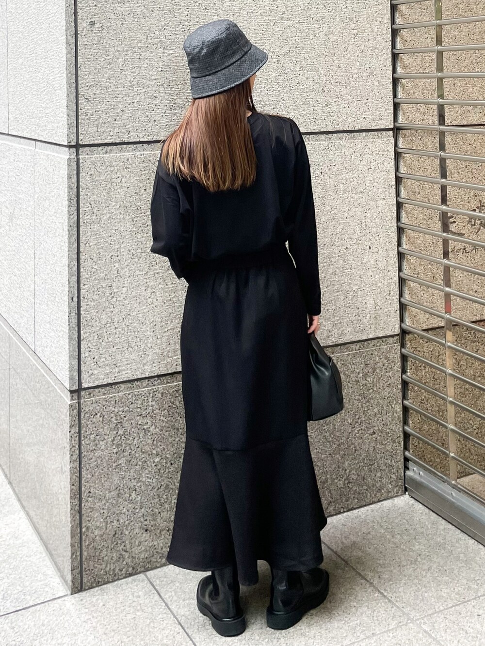 ブラック系のスカート、ブラック系のTシャツ/カットソー、ブラック系のショルダーバッグを着用したレディースの秋コーディネートの2枚目の写真