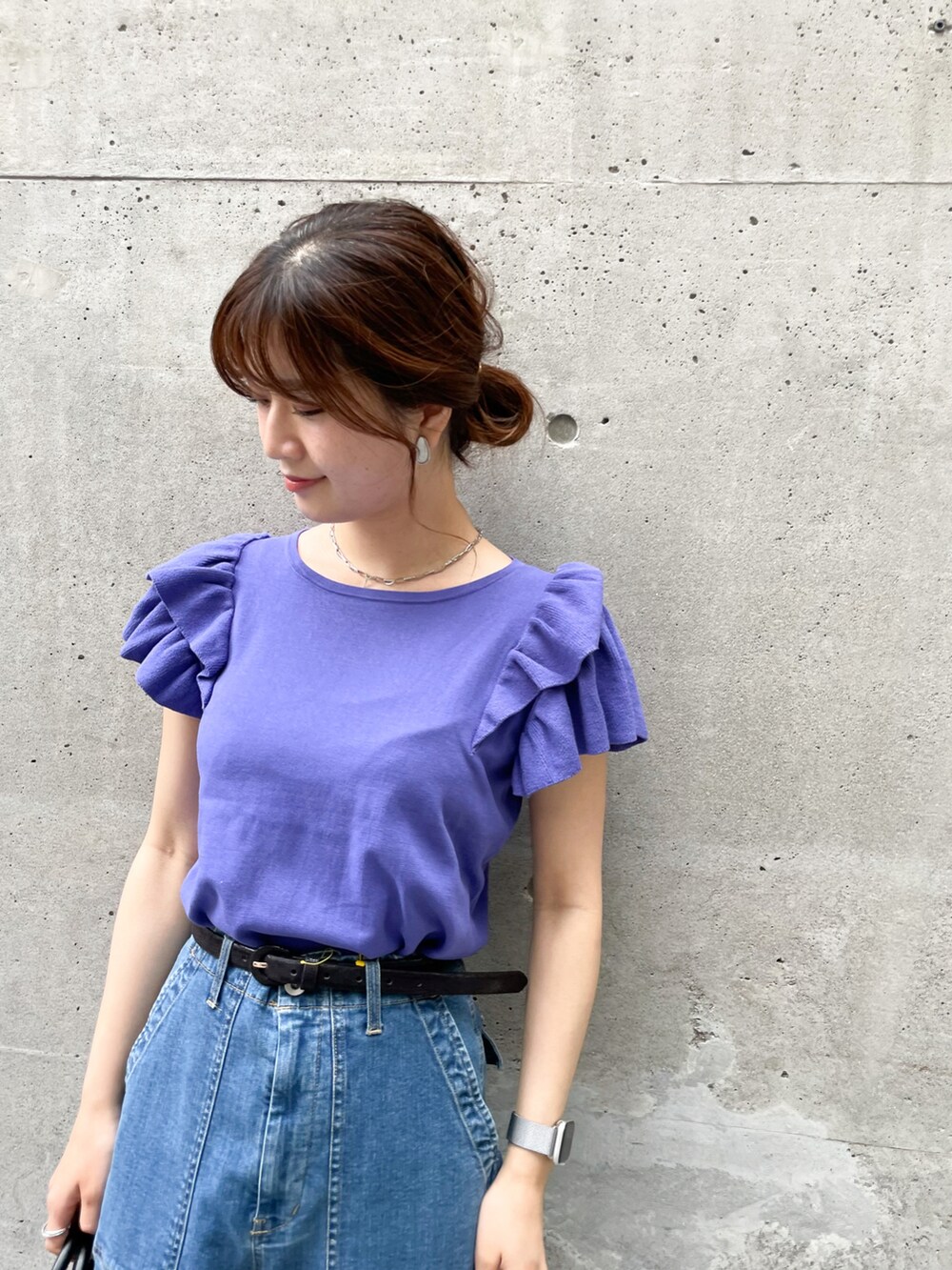 パープル系のニット/セーター、ブラック系のショルダーバッグ、ブルー系のデニムパンツを着用したレディースの春コーディネートの3枚目の写真