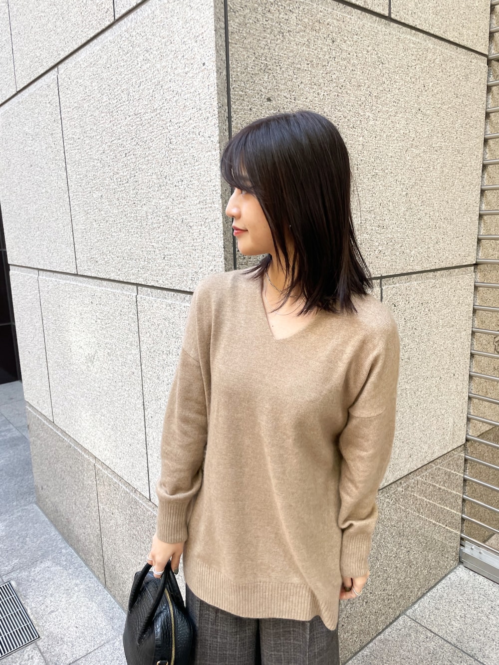 ブラウン系のニット/セーター、ブラック系のその他パンツ、ブラック系のショルダーバッグを着用したレディースの冬コーディネートの3枚目の写真