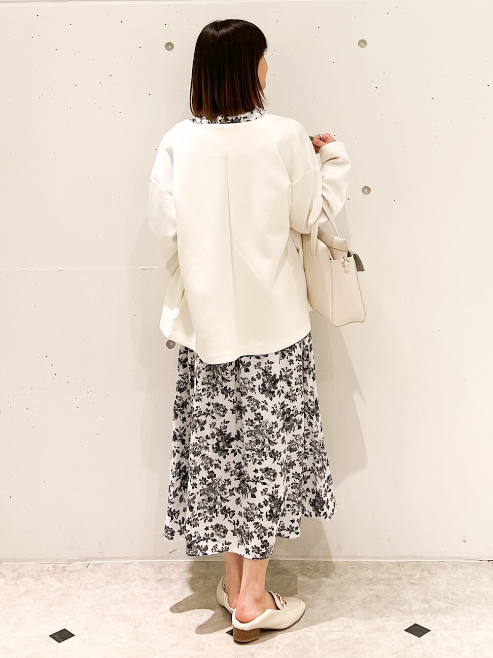 ホワイト系のブルゾン、ホワイト系のワンピース、ホワイト系のショルダーバッグを着用したレディースの春コーディネートの2枚目の写真