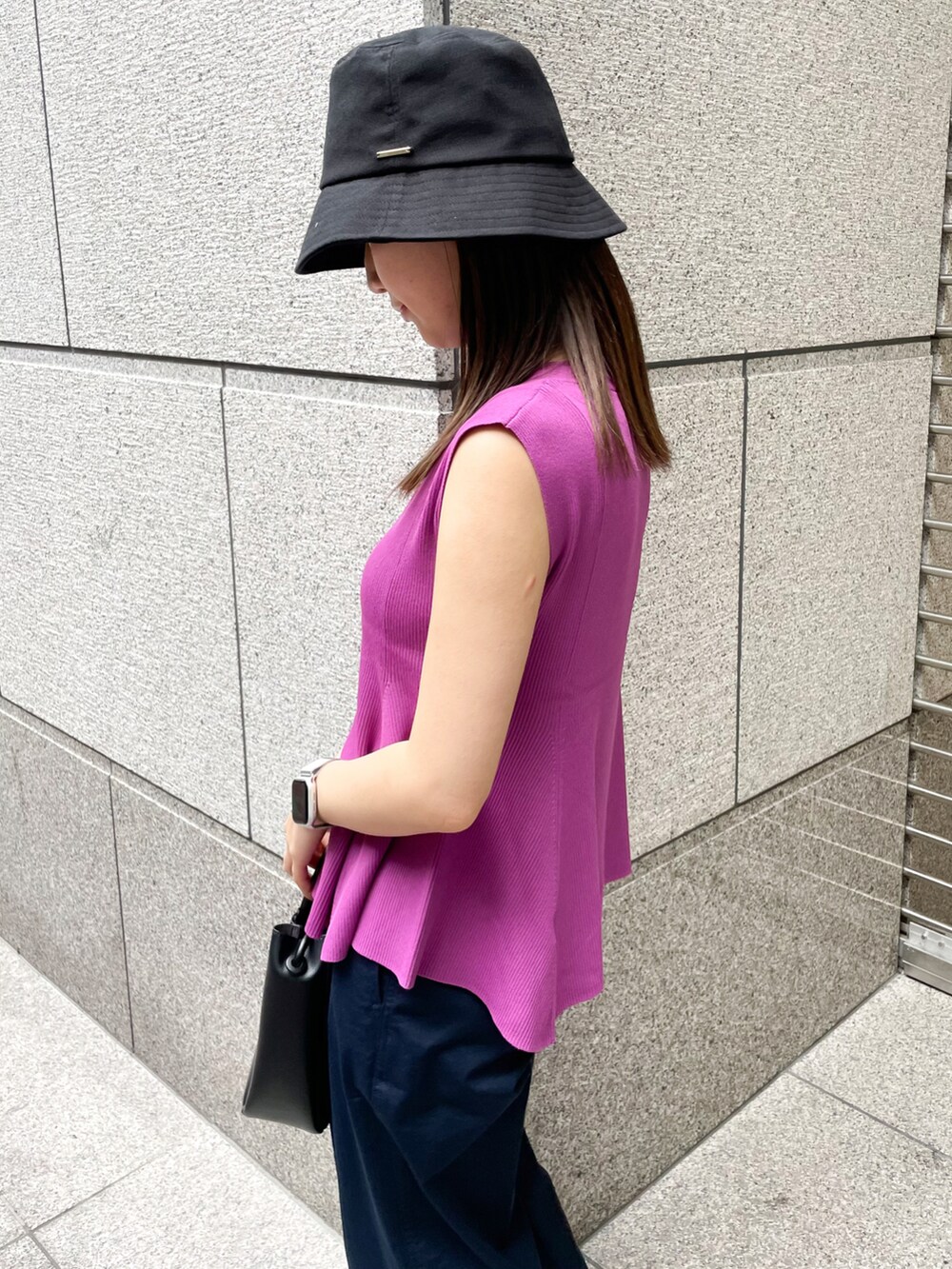 レッド系のニット/セーター、ブラック系のショルダーバッグ、ブルー系のチノパンツを着用したレディースの春コーディネートの4枚目の写真