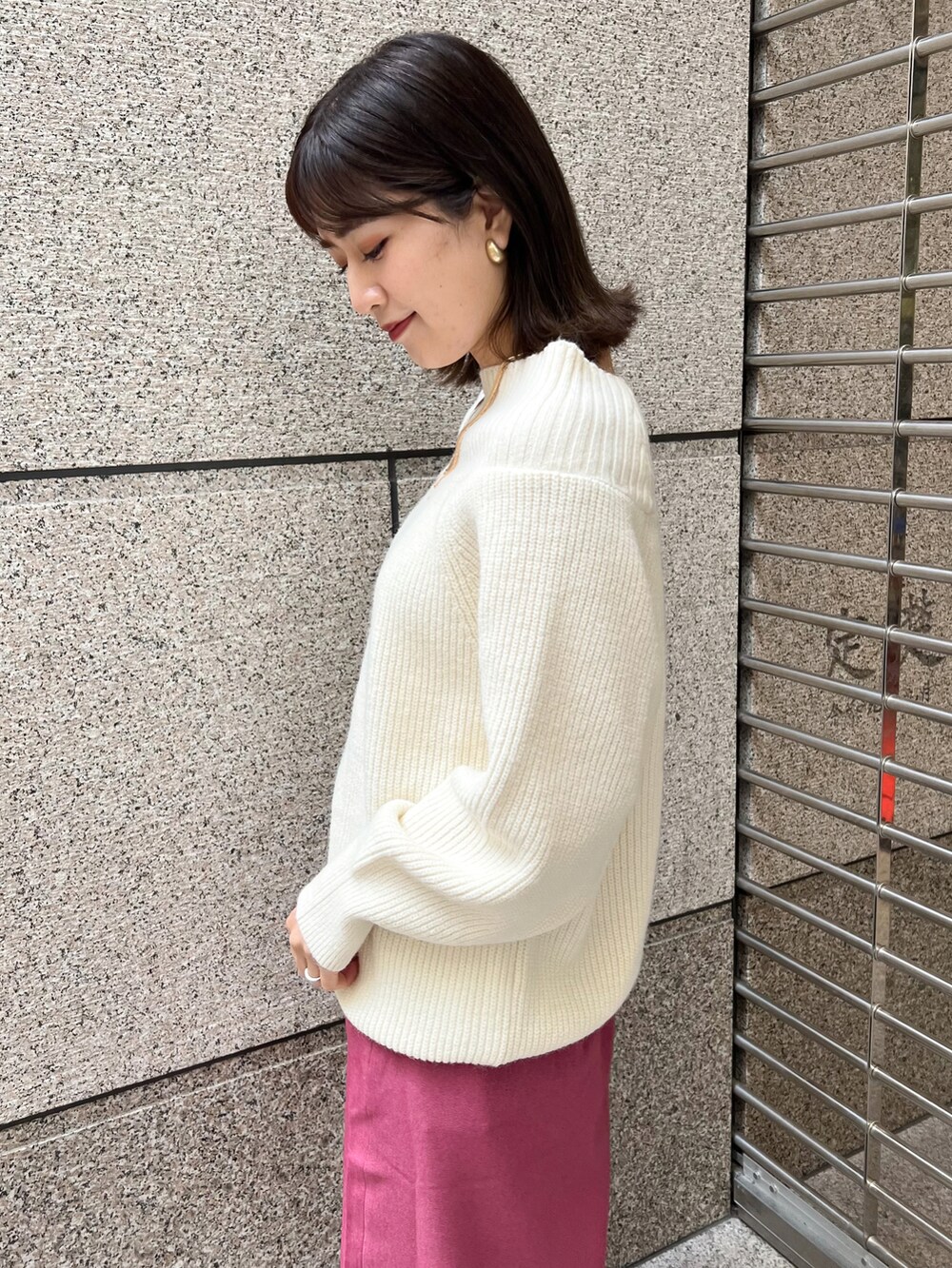 ホワイト系のニット/セーター、ブラック系のショルダーバッグ、ピンク系のスカートを着用したレディースの冬コーディネートの4枚目の写真