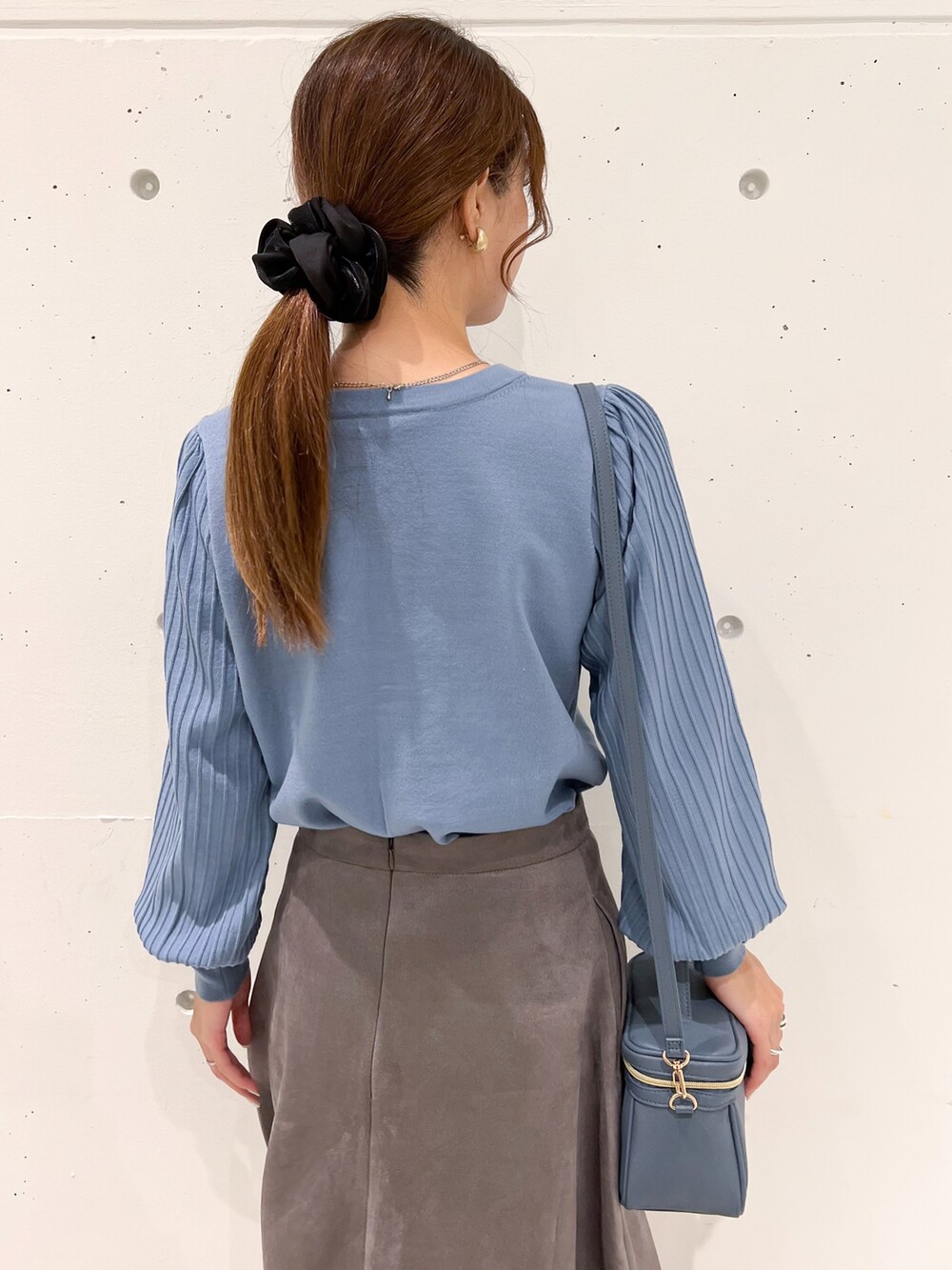 ブルー系のカーディガン/ボレロ、ブルー系のショルダーバッグ、グレー系のスカートを着用したレディースの秋コーディネートの4枚目の写真